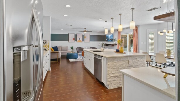 A modern kitchen with a central island, built-in appliances, and pendant lighting.