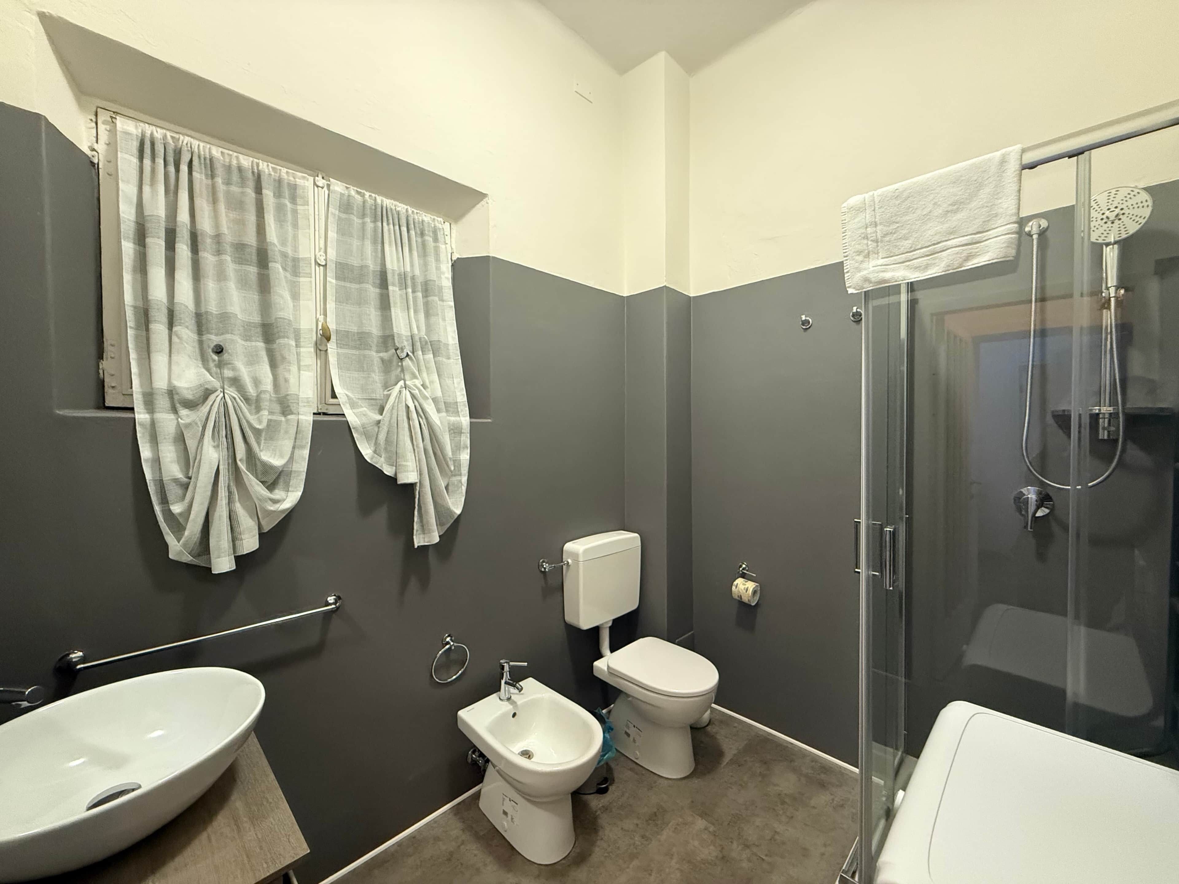 A bathroom with a bidet, toilet, and sink.