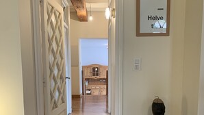 A hallway with a wooden floor, a white door with a diamond pattern, and a small table with a sculpture. - Charming house in a 7-hectare listed property (MONTLAUR)