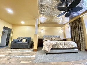 A spacious bedroom with a large bed, a ceiling fan, and a modern design. - Stay in the Old Hauenstein Brewery on the 1st level (New Ulm)