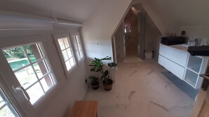 A modern kitchen with a wooden table, potted plants, and a view of the outdoors through large windows. - Completely renovated cottages between Honfleur and Pont Audemer (Saint-Pierre-du-Val)