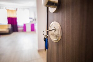 Una puerta con un ojo de cerradura y un llavero con una llave azul.