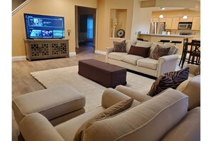 Relax in this stylish living room with a large flat-screen TV, comfortable sofa, and matching ottoman.