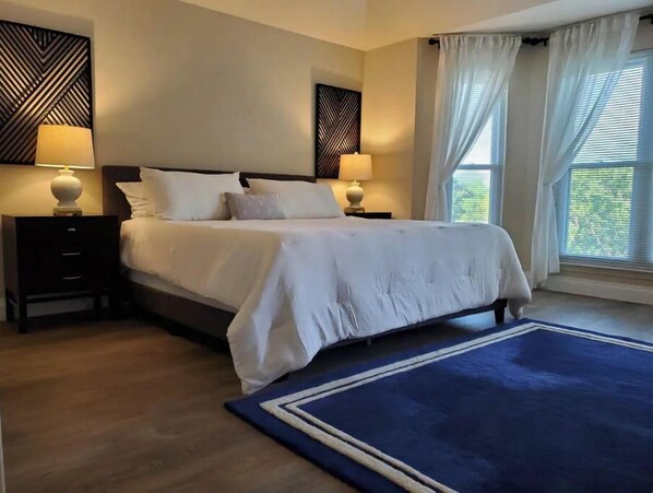 Relax in comfort with a large bed, two bedside tables, and a spacious area rug.