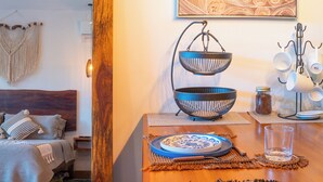 A room with a bed, a wooden bench, a dining table set with plates and bowls, and a wall-mounted light fixture. - TULUM XAMIRA PRIVATE SPA  BALCONY (tulum)