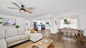 A modern living room with a sofa, coffee table, and dining area.