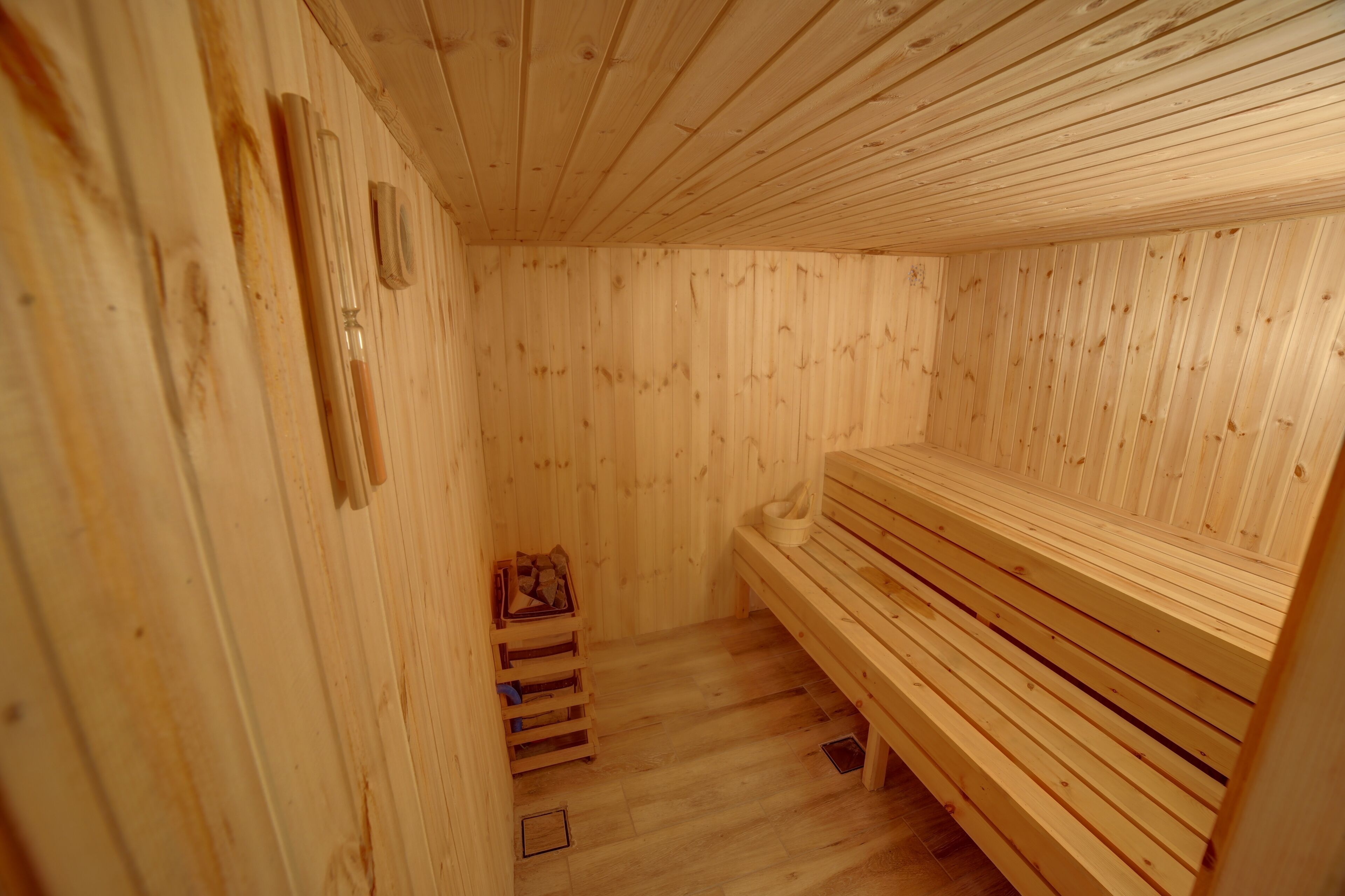 Una sauna in legno con panche e pavimento di legno.