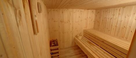 Una sauna de madera con bancos y suelo de madera.