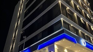 A multi-story hotel with illuminated signage and a modern architectural design. - Alena Hotel (Aqaba)