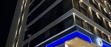 A multi-story hotel with illuminated signage and a modern architectural design.