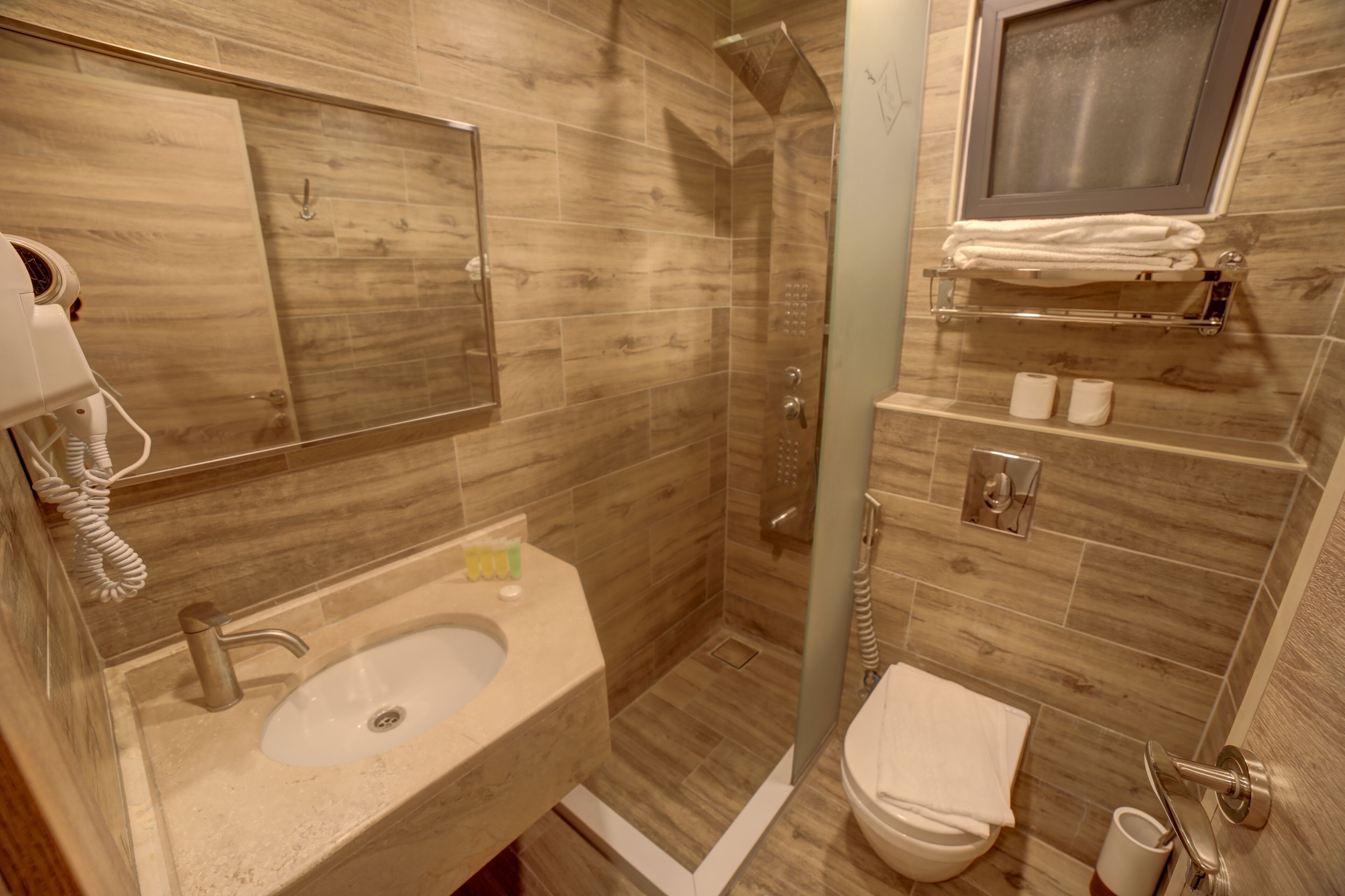 A bathroom with a sink, toilet, and shower area.