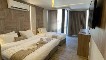 Una habitación de hotel con una cama grande, un televisor y un aire acondicionado.