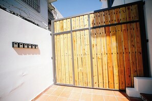 A gated entrance with a wooden fence and a metal gate.