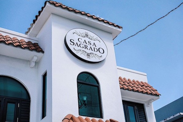 A building with a sign that reads 'CASA SAGRADO' on a white wall.