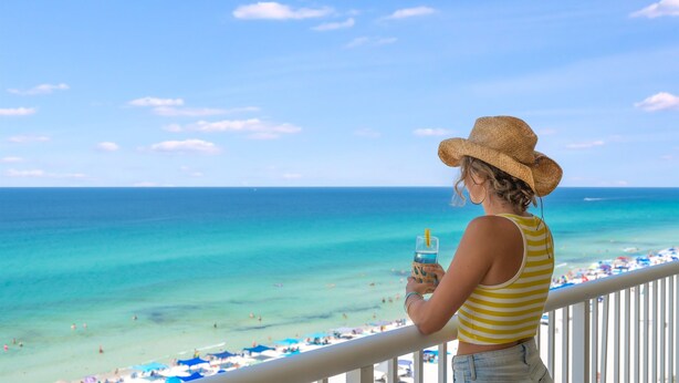 A balcony with a view of a beach and ocean. - Spacious Corner Unit! Oceanfront! Majestic! Pools! (Panama City Beach)
