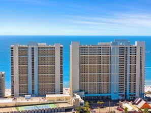 Un hotel moderno de gran altura con varias plantas, una zona de piscina y vistas al océano.
