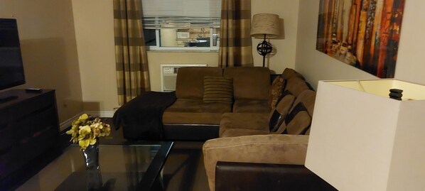 Relax in style with a comfortable sofa, flat-screen TV, and a unique lamp, perfect for unwinding and entertainment.