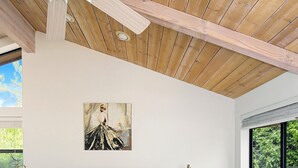 A bedroom with a bed, a ceiling fan, a nightstand, a lamp, and a window with a view of greenery. - Red Rock Retreat • Golf • Hiking & Biking Trails • Views • Dining VOC •Adventure (Sedona)