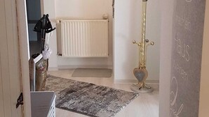 A hallway with a radiator, a coat rack, and a heart-shaped decoration on the wall. - Vacation apartment "Haus Herzblick" directly on the pilgrimage path "Herzweg des Friedens" in Ts. (Berghausen)