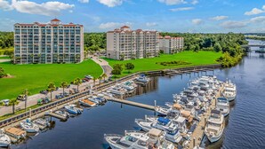 A marina with multiple boats docked, surrounded by a large hotel complex with multiple buildings and a well-maintained lawn. - Intercostal Waterway Hotel Style Room -- 5 min from the beach! (North Myrtle Beach)