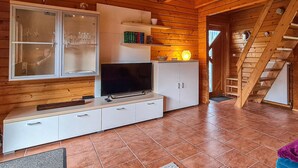 A cozy cabin interior with a wooden interior, a TV on a cabinet, and a staircase. - 2 bedroom cozy home in Boiensdorf (Boiensdorf)