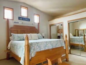 Un dormitorio con cama con dosel, cabecera de madera y un cartel que dice 'Lake House'.