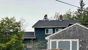 A house with a wooden deck and a large window.