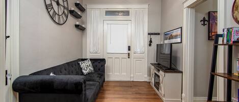 A compact living space with a black sofa, a television, and a bookshelf.
