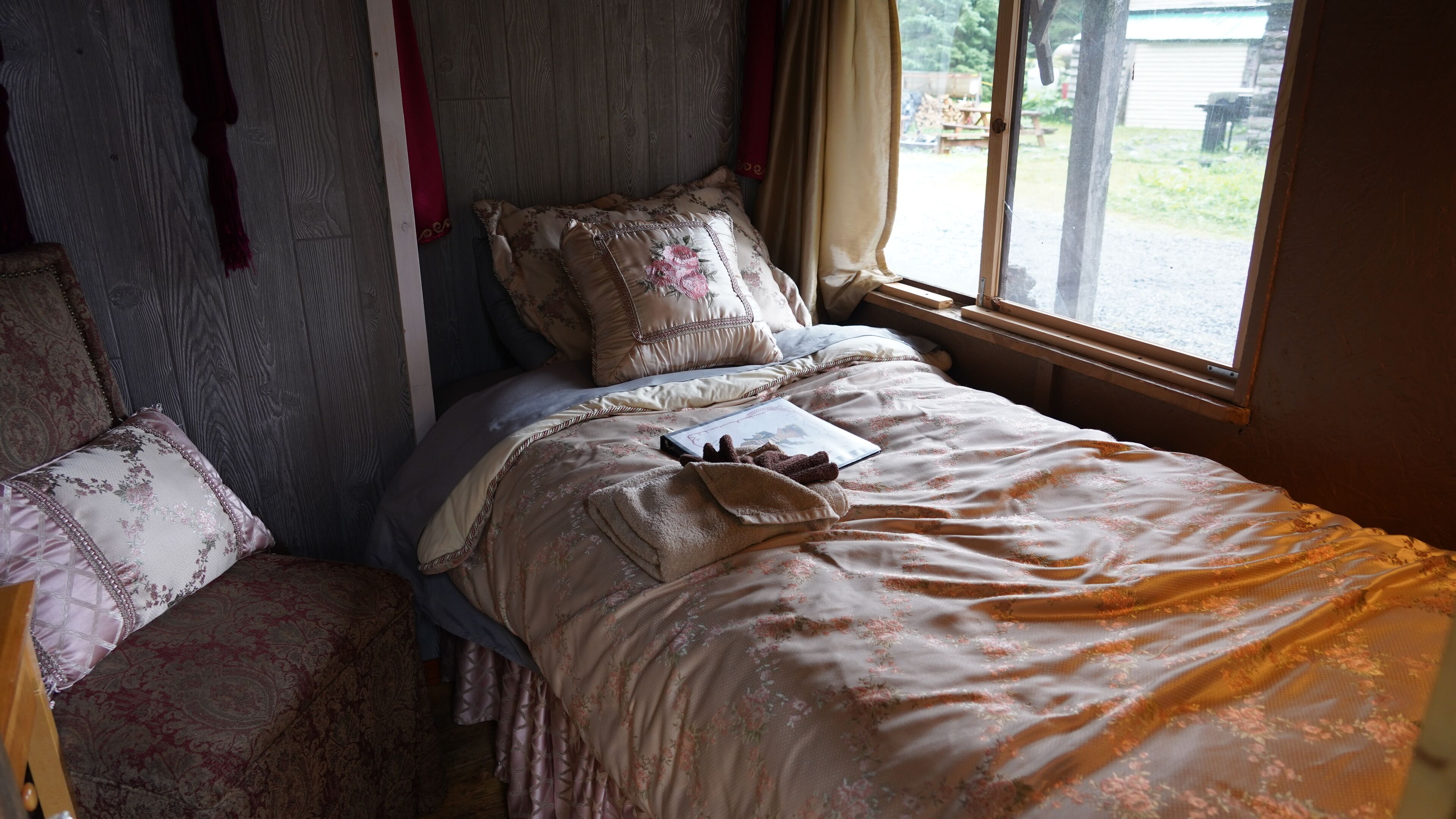 Ein Schlafzimmer mit Bett, Kissen, Nachttisch und Fenster.