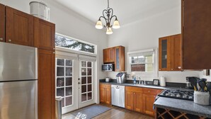 A kitchen with wooden cabinets, stainless steel appliances, and a wine rack.