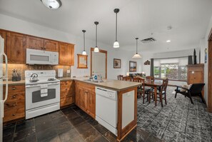 Une cuisine moderne avec des meubles en bois, un four à micro-ondes encastré et un lave-vaisselle.