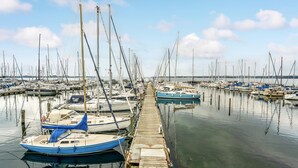Een jachthaven met talloze zeilboten afgemeerd aan houten steigers.