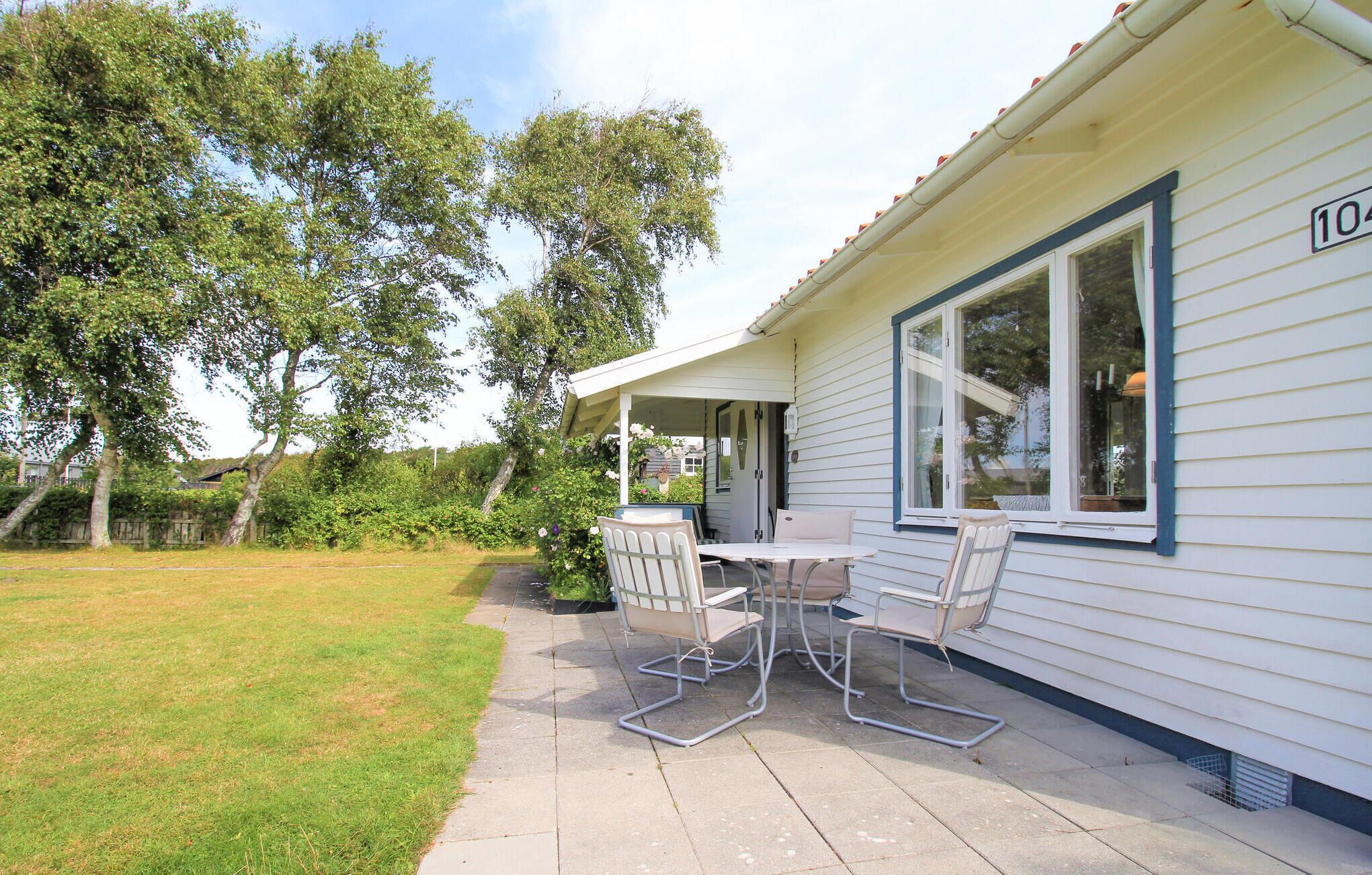 Ein eingeschossiges Haus mit einer überdachten Terrasse.