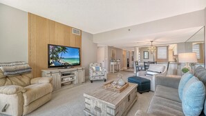 A living room with a television, sofas, a coffee table, and a dining area. - Stunning 2 BR Condo views of the Gulf and Lake (Longboat Key)