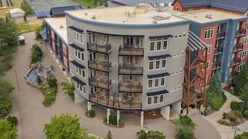 A multi-story building with a central courtyard, balconies, and a parking area.