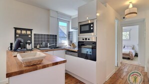 Una cocina moderna con horno empotrado, cafetera y lavabo.