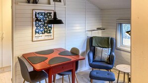 A room with a red table, blue chair, and a framed picture on the wall. - 1 bedroom lovely home in Nexø (Nexø)