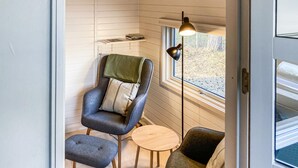 A cozy interior with a chair, ottoman, small table, and a floor lamp near a window. - 1 bedroom lovely home in Nexø (Nexø)
