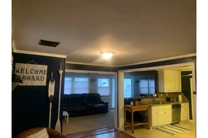Relax in this inviting living area with a sofa and table, leading to a well-equipped kitchen with a dishwasher.
