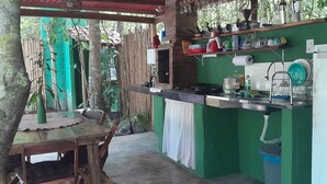 A compact kitchen with a green wall, a sink, a stove, and a refrigerator. - Chalés Guigó (Prado)