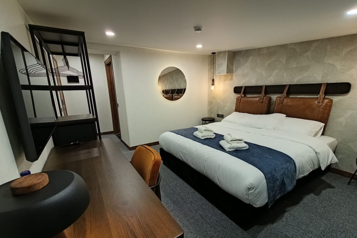 Een moderne hotelkamer met een bed, een bureau en een stoel.