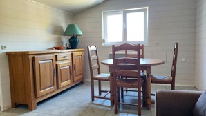 A dining area with a wooden table and chairs, a cabinet, and a lamp.