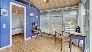 A room with a wooden floor, a bed with a white headboard, a desk with a chair, a window with blinds, and a hanging light fixture. - Amazing home in Broager with kitchen (Broager)