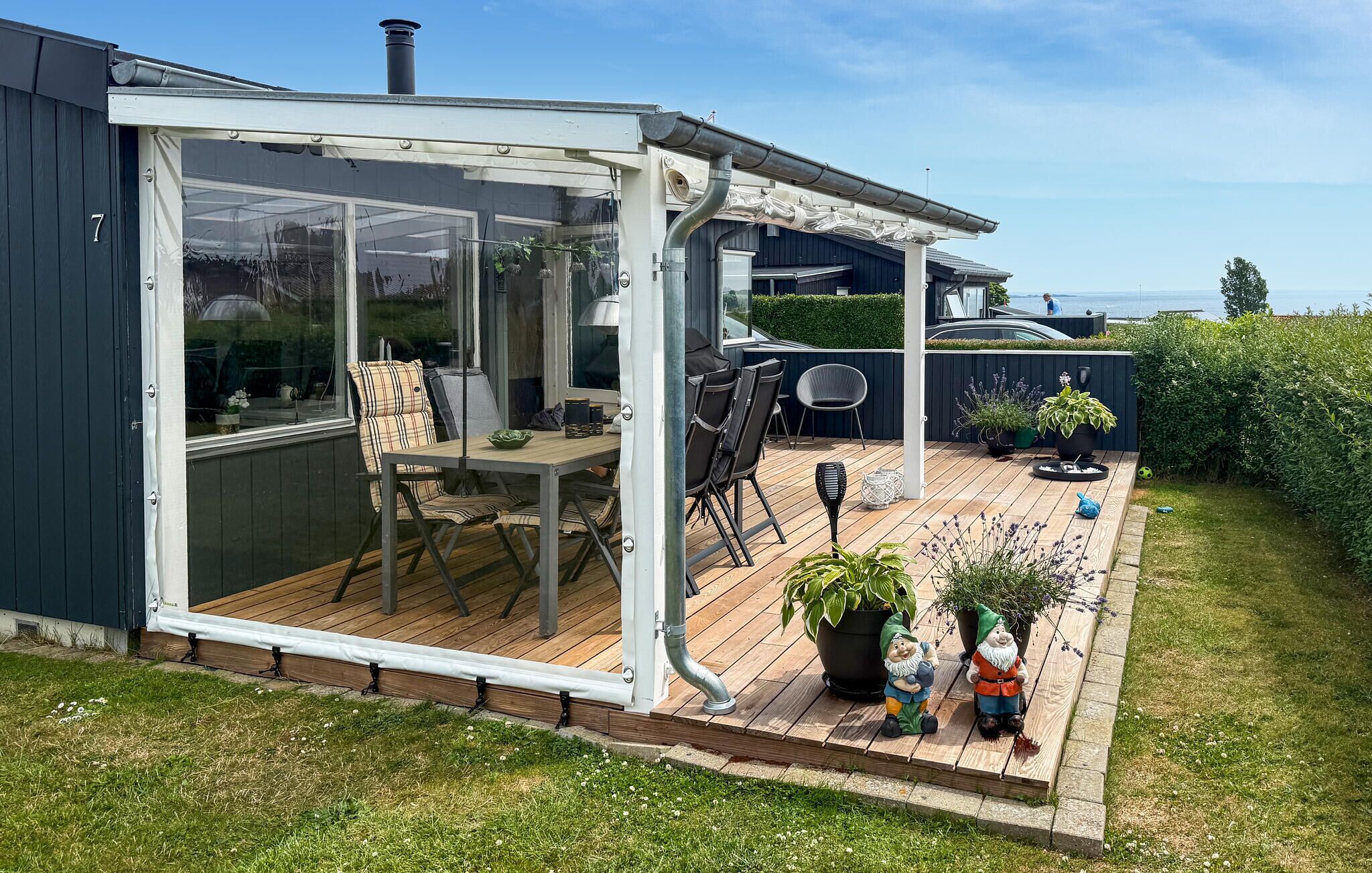 A covered patio with a table and chairs, a grill, and garden decorations.