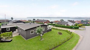 A residential area with modern houses, a well-maintained lawn, and a view of a body of water. - Pet friendly home in Hejls with WiFi (Hejls)