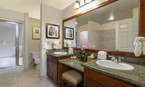 Bathroom features two sinks with granite countertops, a large mirror, and a toilet.