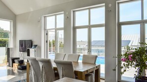 A spacious room with large windows, a dining table, and chairs. - 4 bedroom stunning home in Ramdala (Ramdala)