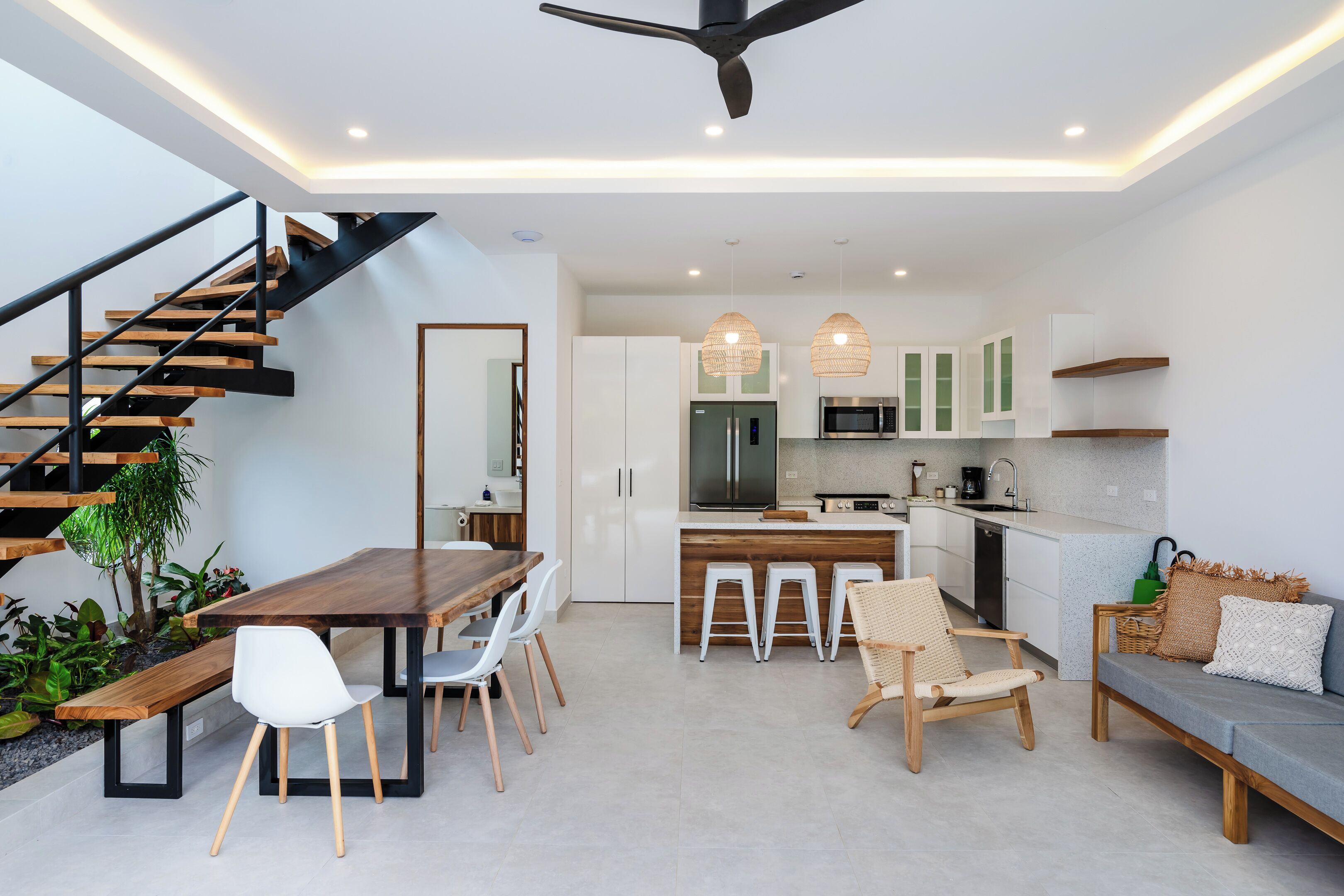 A modern kitchen with white cabinets, a central island, and pendant lighting.