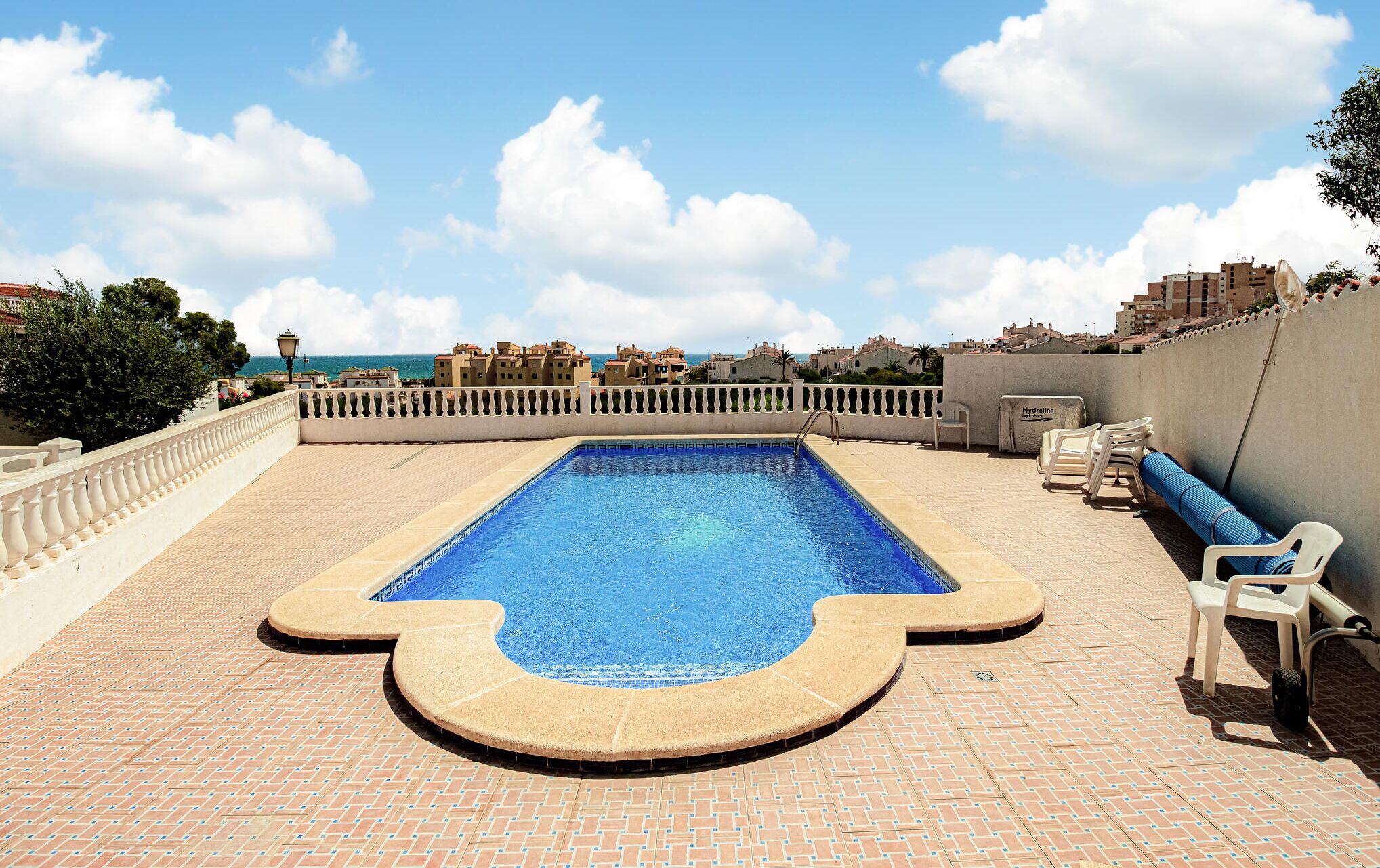 Ein Dachpool mit freiem Blick auf das Meer und Gebäude im Hintergrund.