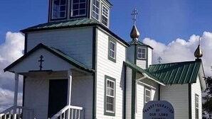A church with a white fence, a green roof, and a sign reading "Transfiguration of Our Lord". - Beach/Kenai Center 5 minutes (Kenai)